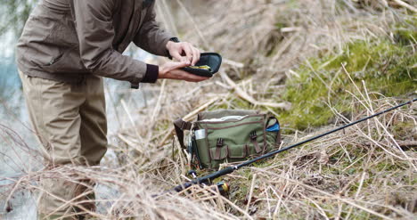 Confident-Man-Preparing-Fishing-Rod-At-Lakeshore-4