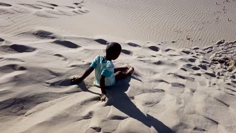 niño jugando en las dunas de arena en sudáfrica