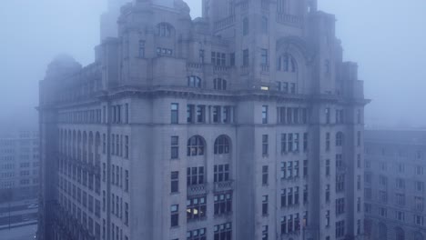 dense fog cover aerial rising view liverpool liver building in thick gloomy weather visibility