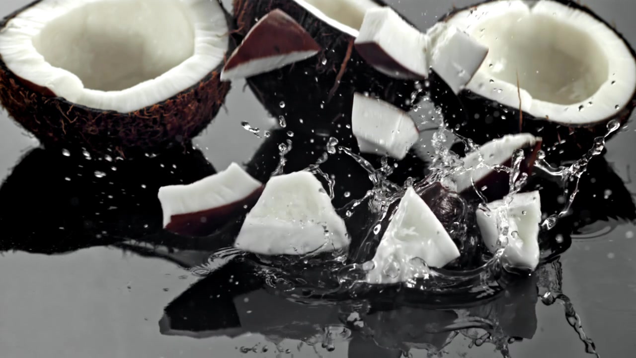 Fresh Coconut Pieces Splashing into Water in Slow Motion