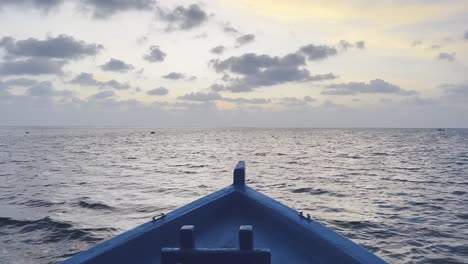 Scenic-Drive-on-a-Traditional-Dhoni-Boat-Across-the-Turquoise-Waters-of-Maldives,-as-the-Glorious-Sun-Descends-into-the-Horizon,-Painting-the-Sky-with-Hues-of-Gold-and-Orange