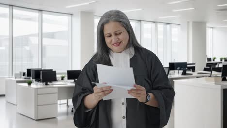 feliz abogada india senior leyendo informes de casos