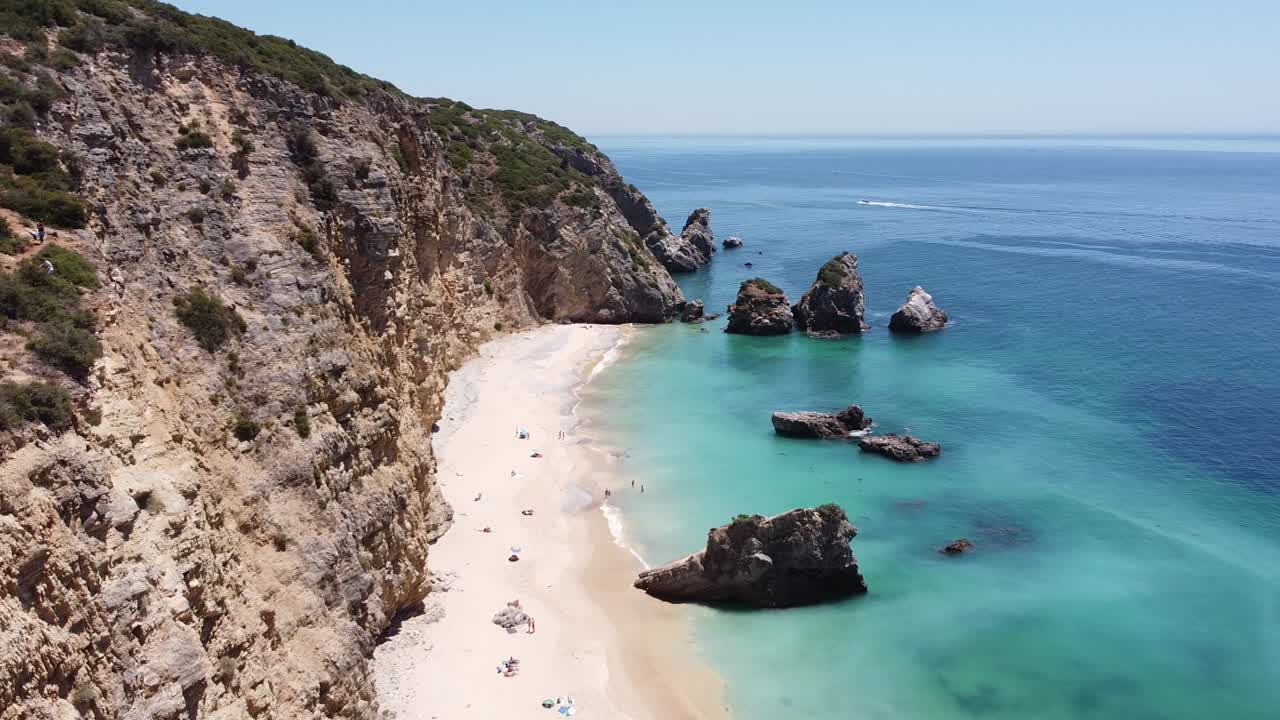 пляж praia ribeira do cavalo возле сезимбры, алентежу, португалия - вид с беспилотника на крутой берег со скрытым райским пляжем и бирюзовым морем