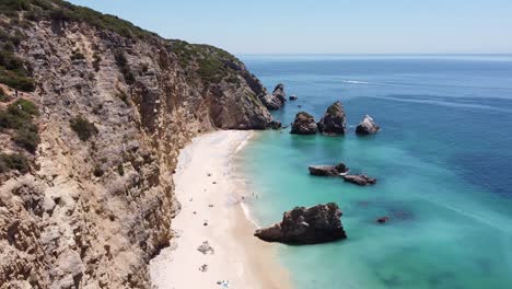 Playa-Praia-Ribeira-Do-Cavalo-Cerca-De-Sesimbra,-Alentejo,-Portugal---Vista-Aérea-De-Drones-De-La-Escarpada-Costa-Con-Playa-Paradisíaca-Escondida-Y-Mar-Turquesa