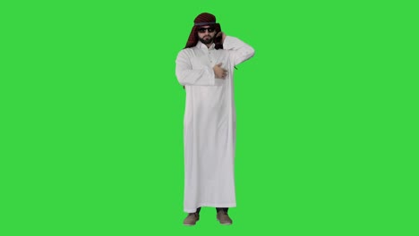 cool sheikh in sunglasses posing on a green screen, chroma key