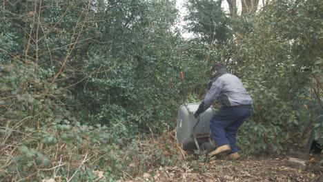 Young-gardener-tipping-out-wheelbarrow-load