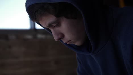 medium closeup of a teenage boy looking sad and depressed