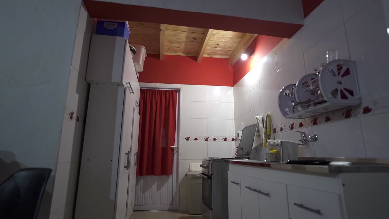 Gradual glide showcases kitchen’s bold two-tone palette and warm wood ceiling overhead. Ideal for vibrant rental listings or cooking content.