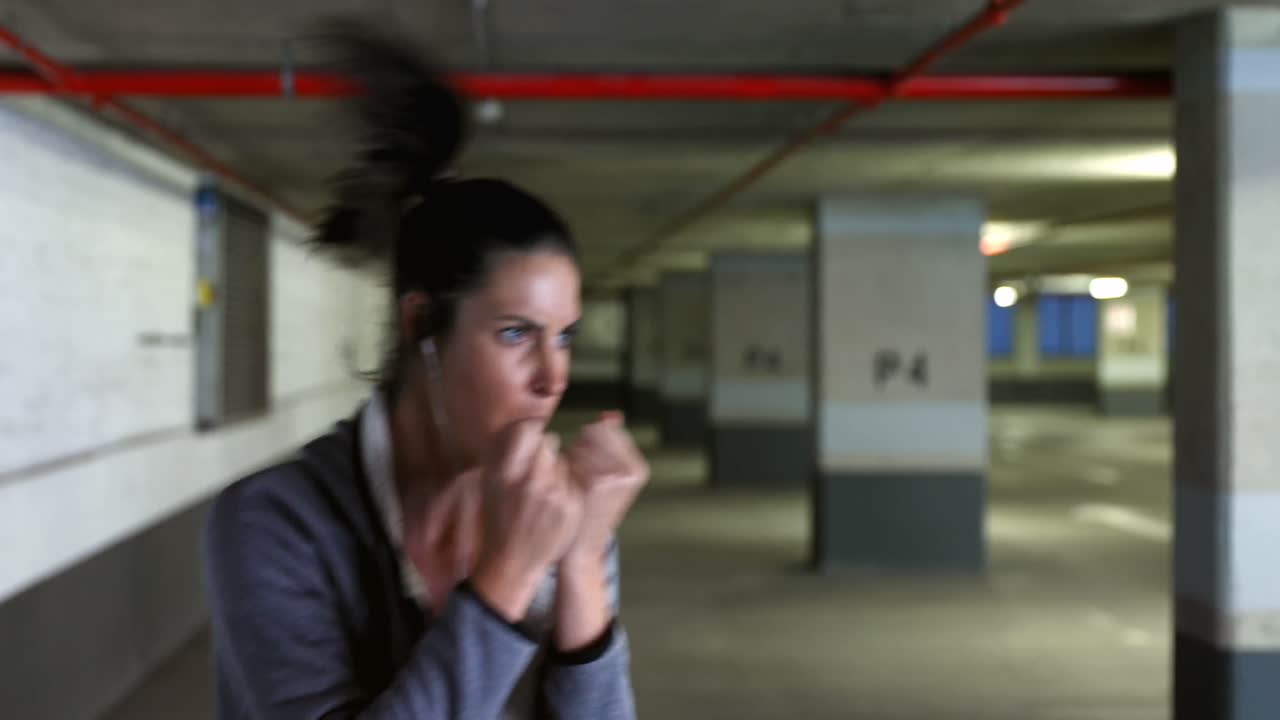 mujer practicando boxeo en el estacionamiento subterráneo 4k