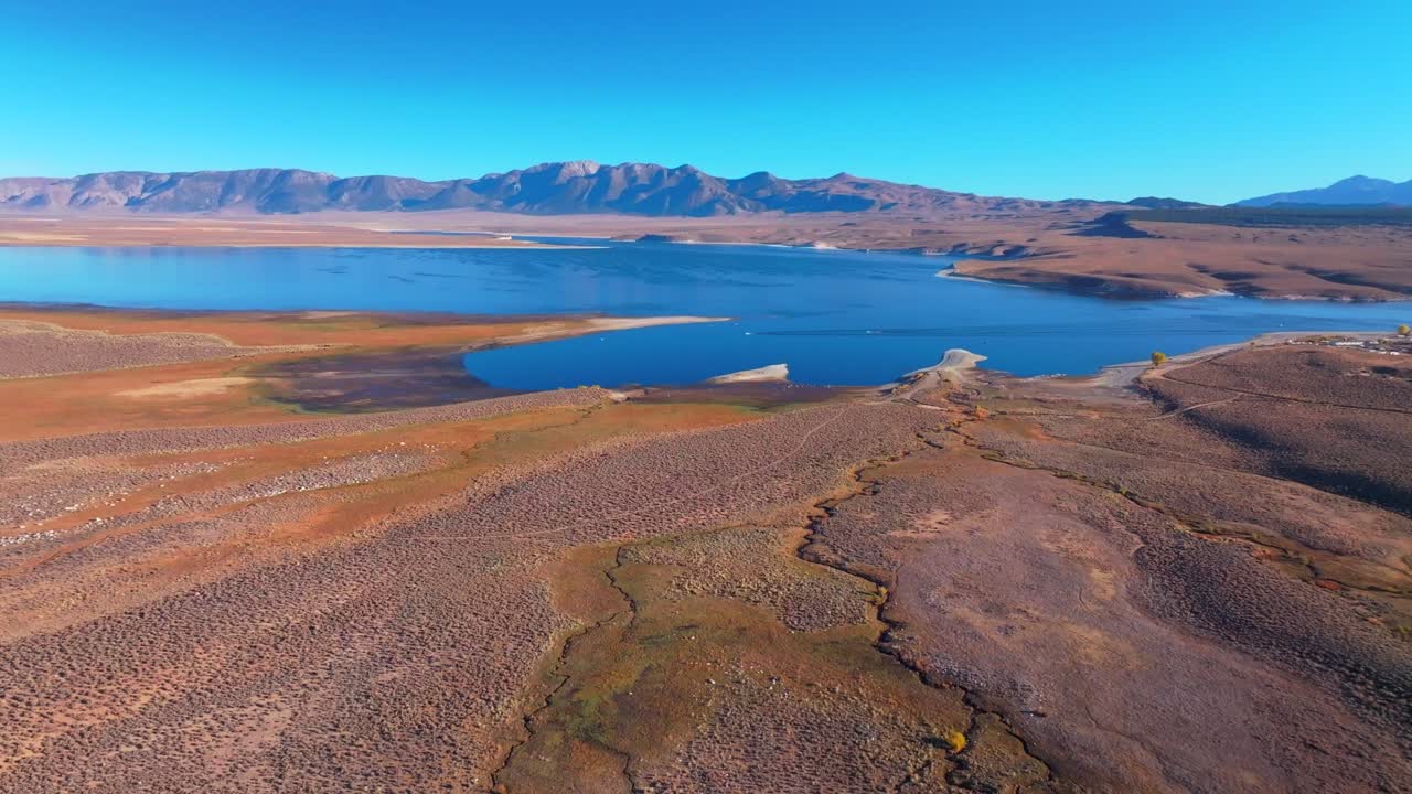 Calm Crowley Lake Stone Columns Marina boats fishing Mammoth Lakes Mountain California aerial drone October Fall autumn morning blue sky Bishop Toms Place Sierra hilltop hot springs forward motion