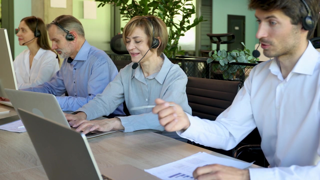Team eterogeneo di operatori di call center al lavoro in un ufficio moderno