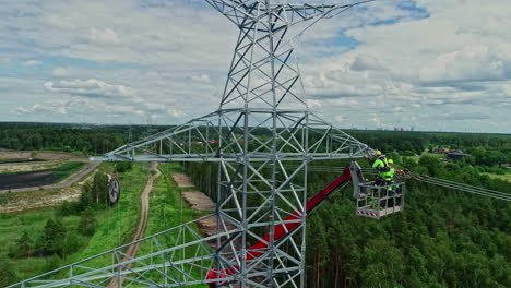 man fixing and repairing electrical mast surrounded by forest and nature