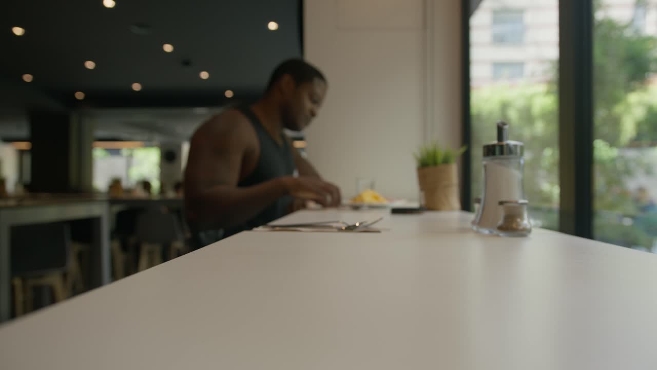 hombre negro borroso caminando para sentarse y desayunar en un hotel en barcelona, españa en 6k