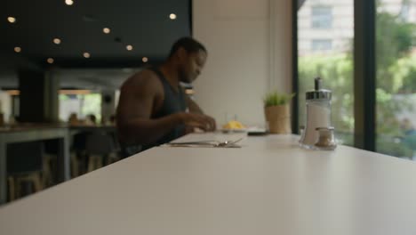 blurry black male walking up to sit down and eat breakfast in hotel in barcelona, spain in 6k