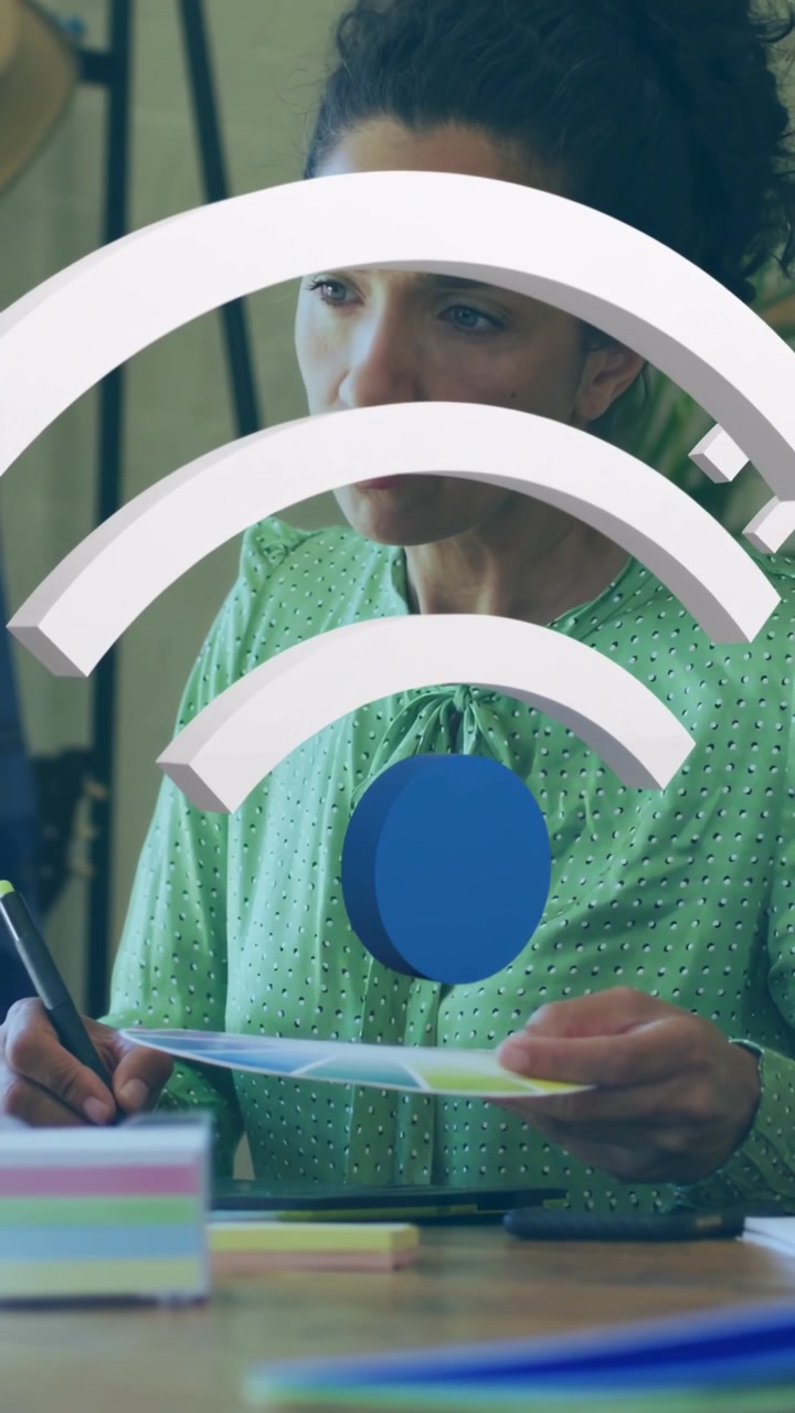 Vertical video: Woman tapping stylus on pad activating Wi-Fi overlay growing, annotating for design