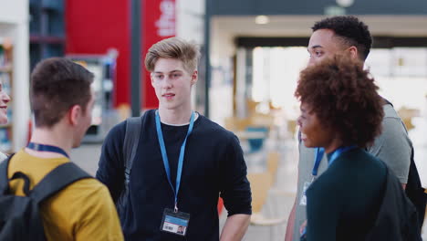 group of college student friends meeting and talking in busy communal campus building