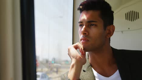 male commuter looking through window while travelling in bus 4k