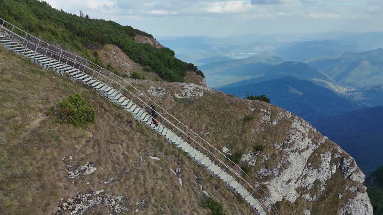 Drone captures male climber ascending ladder on Toaca Peak, Ceahlau, Romania