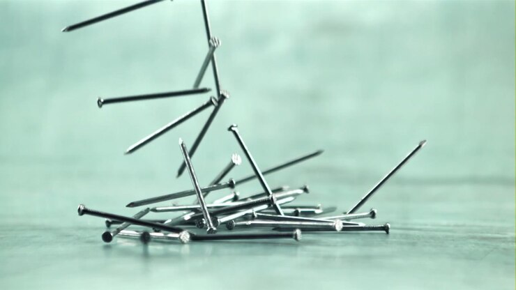 Slow Motion Close-up of Metal Nails Falling and Scattering