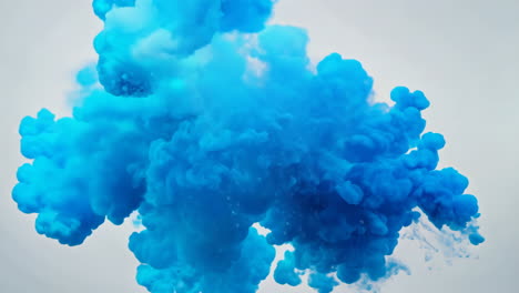 blue smoke cloud during daytime outdoor event. a vibrant blue smoke cloud rises into the sky, creating a striking visual effect during an outdoor activity.