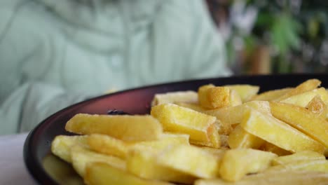 cerca de un plato de papas fritas doradas