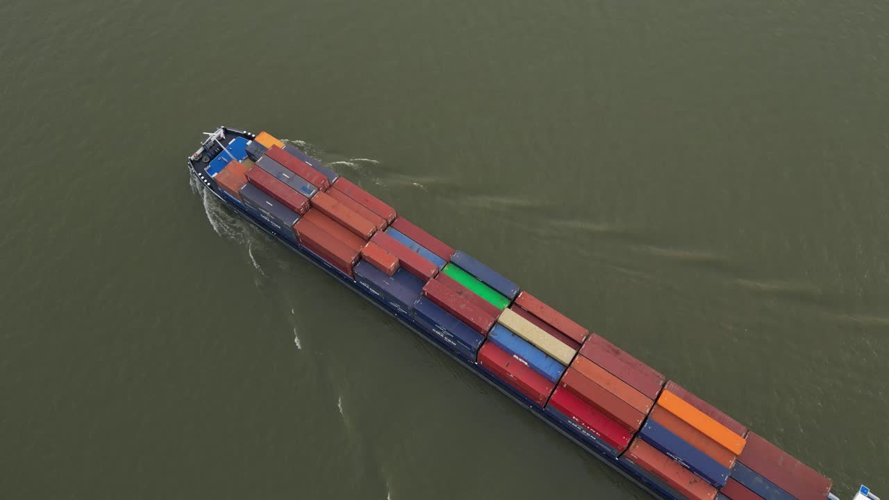 toma aérea del barco new hampshire repleto de contenedores de envío, flotando a través del río.