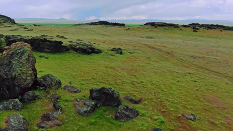 colinas verdes rocosas negras con imágenes de drones aéreos sobrevuelo de aves rápidamente en un día nublado y ventoso cerca del antiguo camino y la interestatal 15 en el centro de utah, ee.uu.