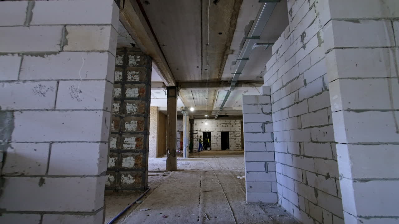 New construction hall under development. Interior view of an unfinished construction site with exposed walls and scaffolding, showcasing progress and structure