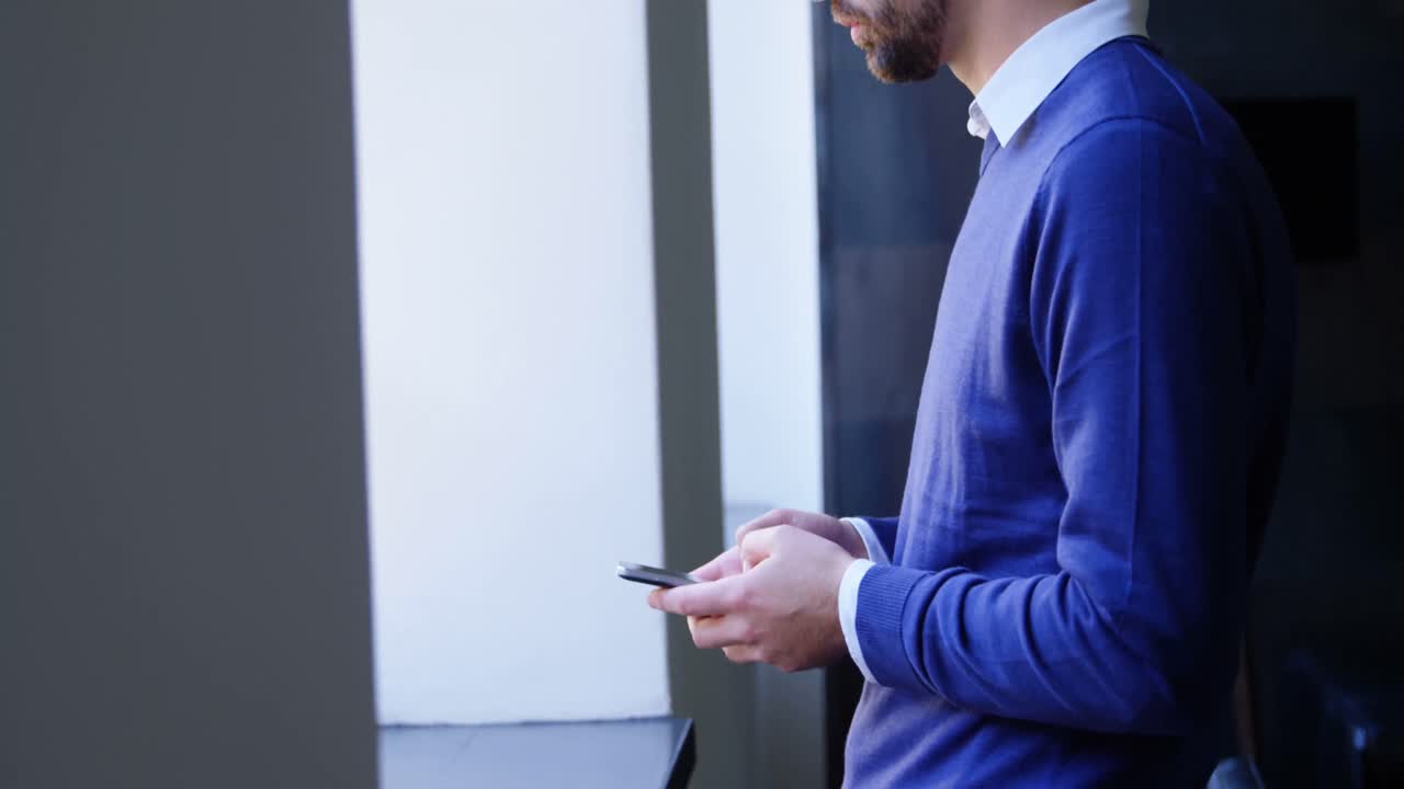 Dirigente che usa il cellulare vicino a una finestra 4k