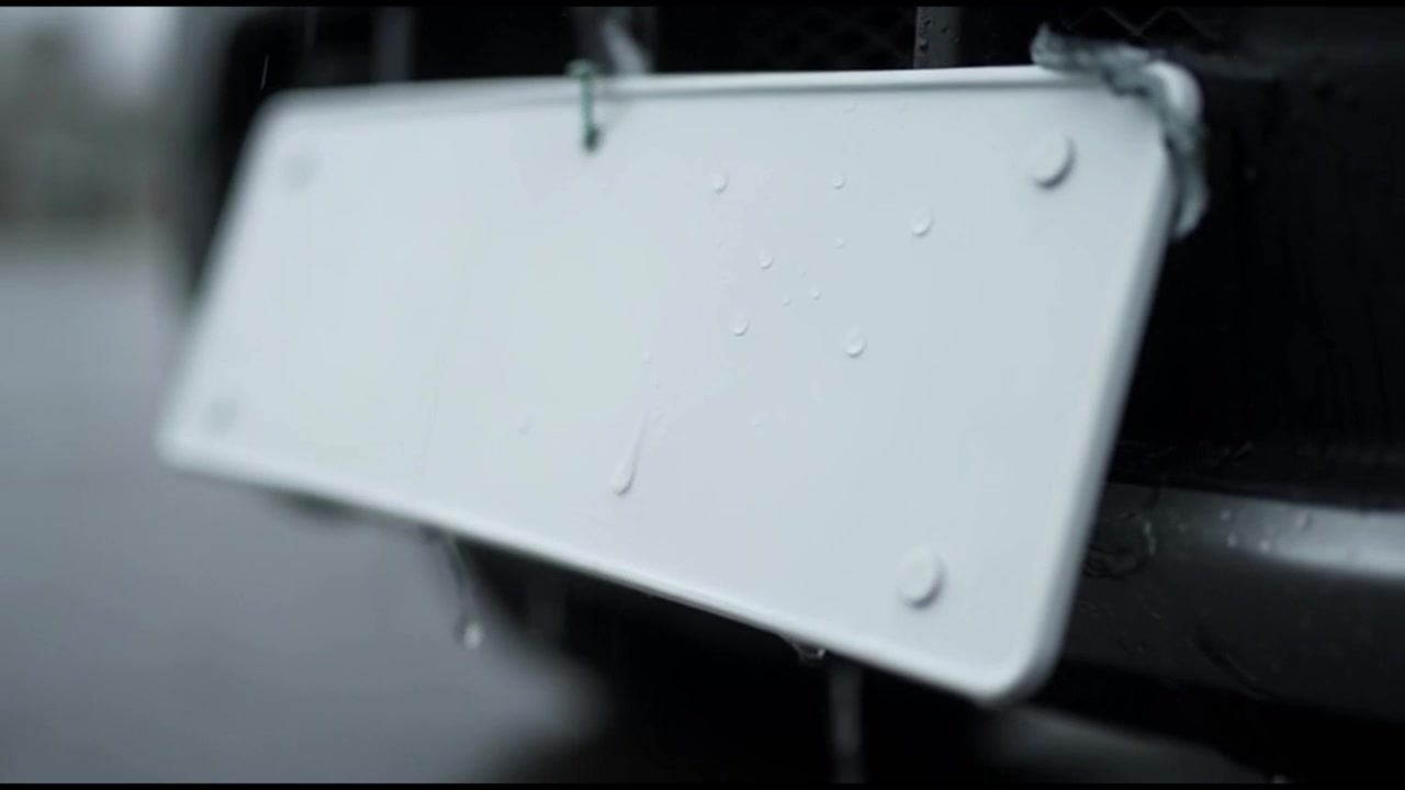 Rainwater Dripping from a Blank Car License Plate