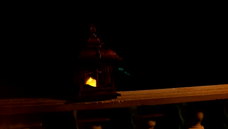 linterna de estilo retro por la noche. hermosa lámpara iluminada de colores en el balcón en el jardín. enfoque selectivo