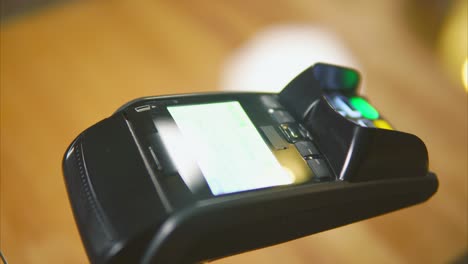 hand processing a payment with pos terminal