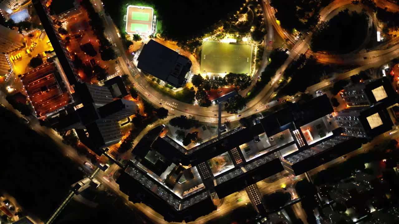 A breathtaking drone view of Hong Kong at night, showcasing the glowing skyline, busy harbor, and vibrant city lights from above.