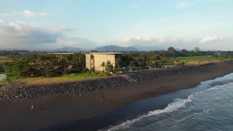 aerial acercándose a wyndham tamansari jivva resort bali al atardecer revelando el salón de la piscina y la fachada del edificio en el paisaje tropical de bali, indonesia