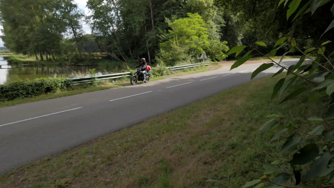 모터사이클리스트가 이 좋은 날에 아름다운 레트로 카페 크루스터를 타고 호수 쪽으로 운전하고 있습니다.