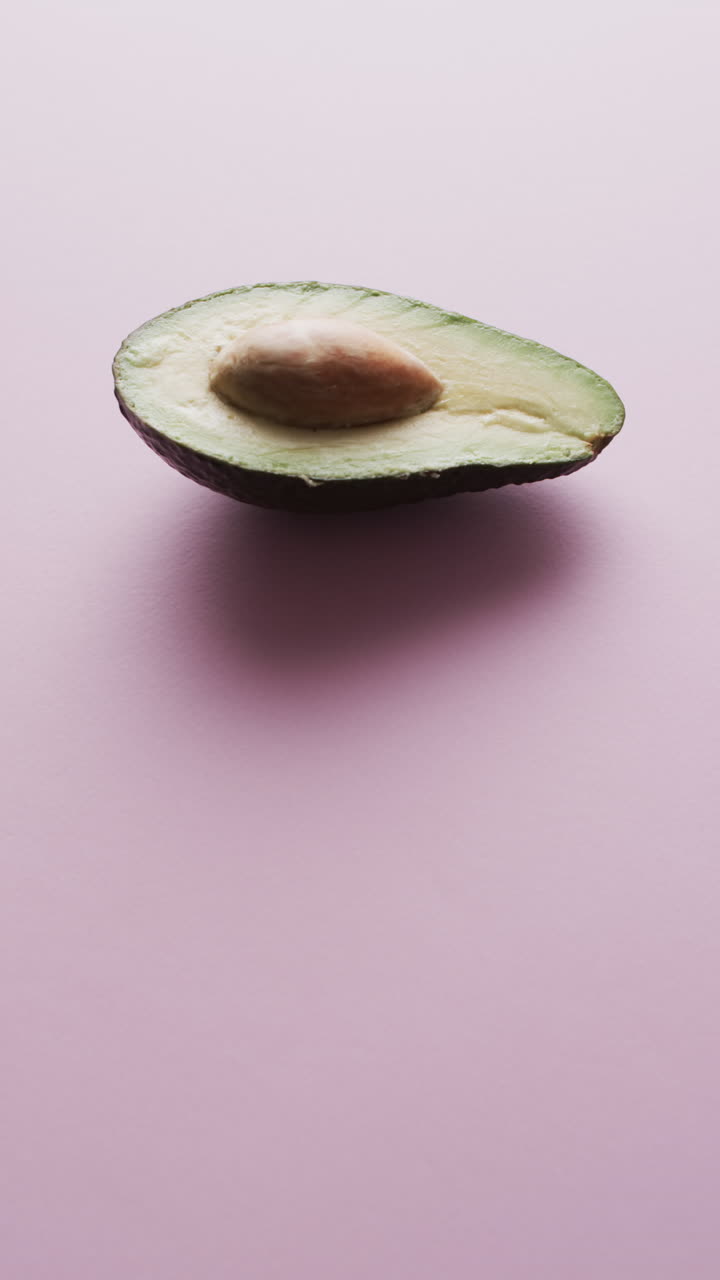 Video verticale di avocado a fette con spazio per il testo su sfondo rosa