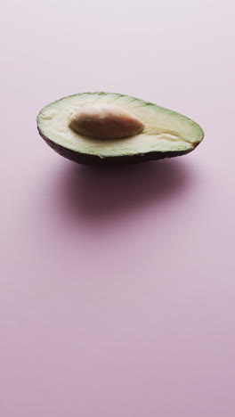 vertical video of sliced avocado with copy space over pink background