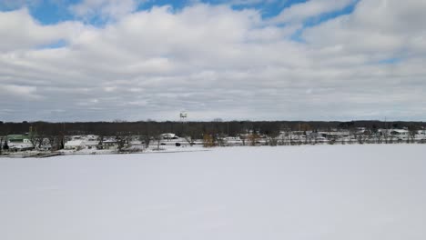 Mona-Lake-in-Winter,-a-drone-descending-over-the-iced-over-surface-in-January-2022