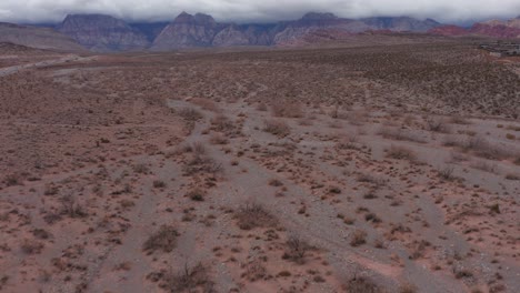 tiro aéreo bajo que se inclina hacia arriba para revelar un cañón de roca roja cubierto por espesas nubes en las vegas, nevada