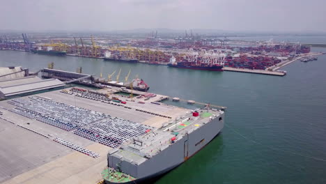 vista aérea del concepto de logística de vehículos comerciales, automóviles y camionetas que esperan ser cargados en un buque de transporte de automóviles rodante