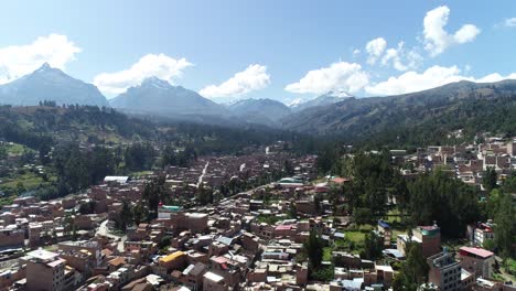 beautiful aerial view of an andean city nestled between lush green hills and towering snow-capped mountains. perfect for travel documentaries, tourism content, and landscape photography.