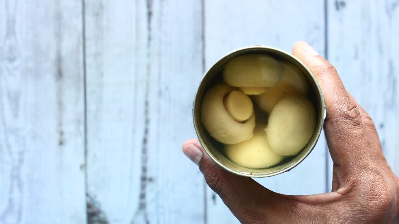 캔으로 된 버섯을 들고 있는 위쪽 전망,