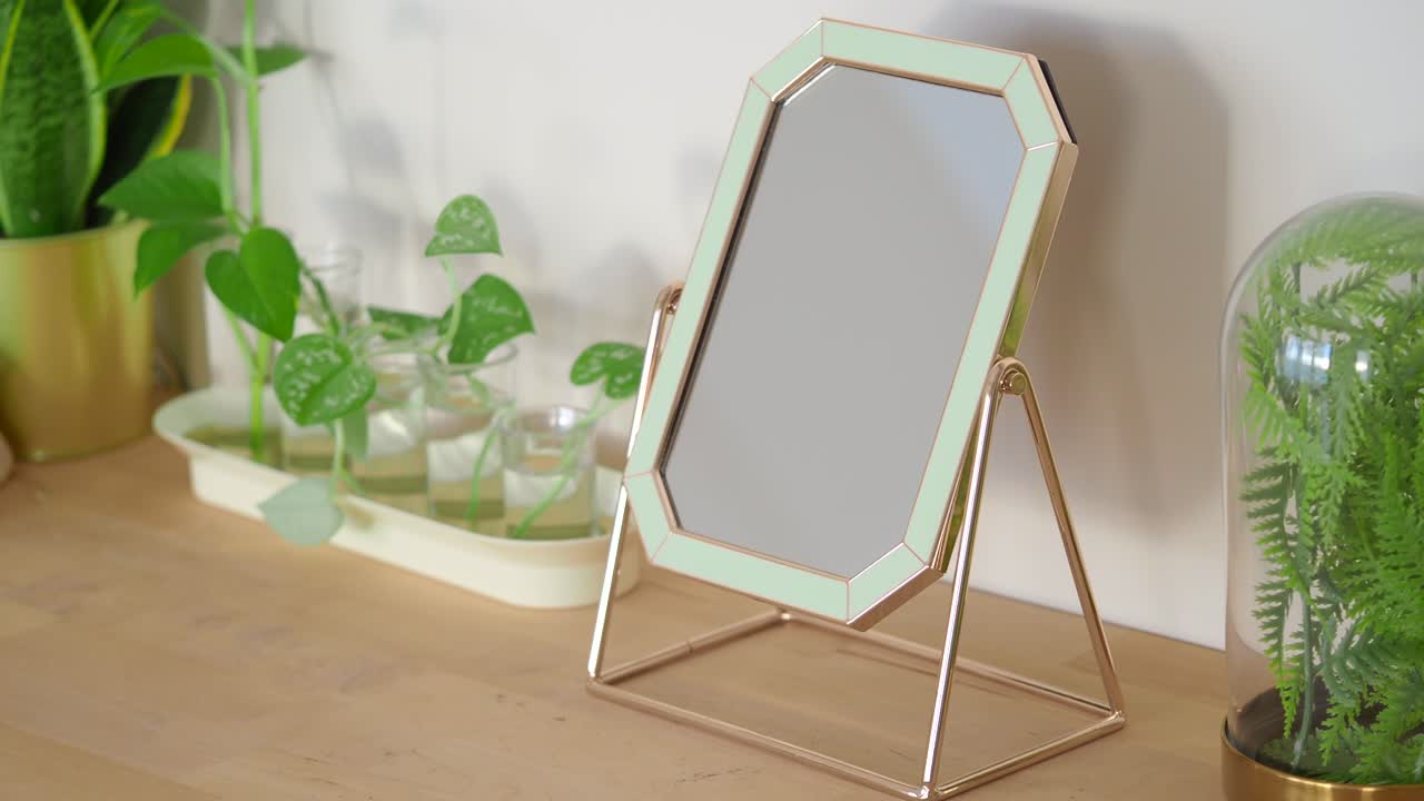 Specchio decorativo moderno con piante su un tavolo di legno