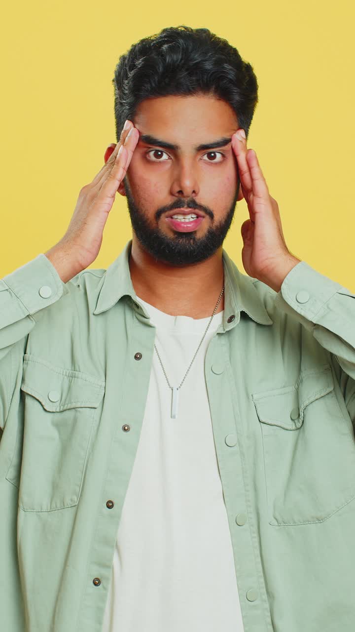 Indian man rubbing temples to cure headache problem suffering from tension and migraine stress pain