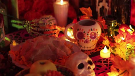 day of the dead table with offerings of food and sugar skulls, establisher