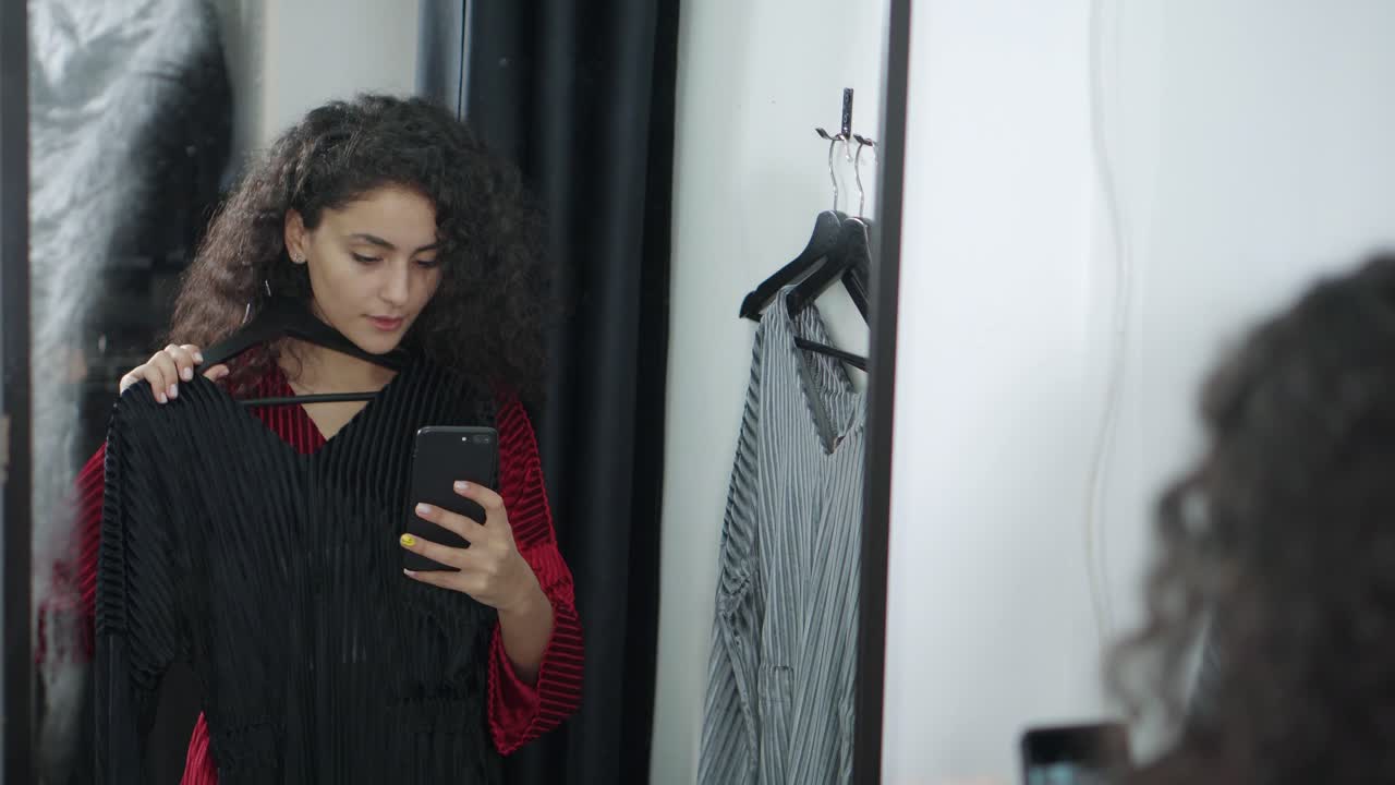 여자 는 드레싱  에서 옷 을 입으려고 한다