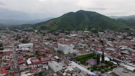 tomada panorámica de tecalitlan, jalisco con la catedral y las montañas tropicales en el fondo, méxico - estableciendo el vuelo de drones