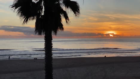 silueta de algunos surfistas contra el sol durante la puesta de sol, playa de carcavelos