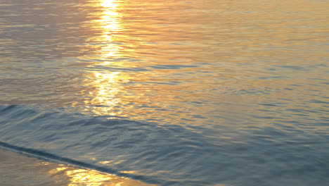 Quiet-sea-waves-washing-shore-at-sunset