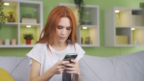 Mujer-Joven-Enviando-Mensajes-De-Texto-Pensativamente-Por-Teléfono-En-Casa.